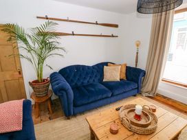 A living room with a blue sofa and wooden table at 18 Main Street