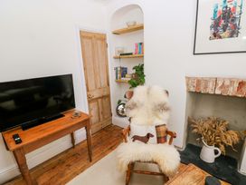A living room with a television, bookshelf, and chair at 18 Main Street