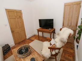 A living room with a tv and a chair at 18 Main Street