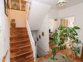 A staircase with a plant and pottery in a hallway at 18 Main Street