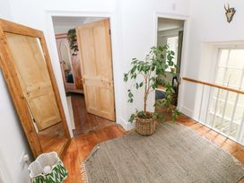 A hallway with doors, a mirror, and a plant at 18 Main Street 