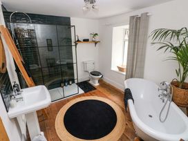 A bathroom with a bathtub, shower, and sink at 18 Main Street