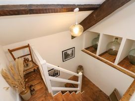 A stairwell with a chair, photographs, and glass jars at 18 Main Street
