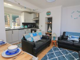 A living room with a kitchen and seating area at The Hideaway in 