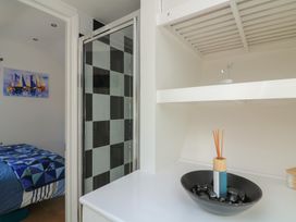 A bathroom with a shower and a decorative shelf at The Hideaway in 