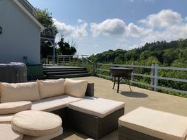 An outdoor area with a sofa and grill at 1 Bryn Beudy Narberth