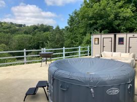 An outdoor area with a hot tub, sofa and storage shed at 1 Bryn Beudy, Narberth