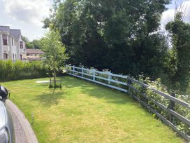 A garden with grass, a tree, and a fence at 1 Bryn Beudy Narberth