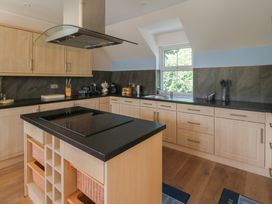 A kitchen with cabinets, stove, sink and countertop at 1 Bryn Beudy, Stepaside
