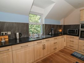 A kitchen with a window, sink, and microwave at 1 Bryn Beudy in Stepaside