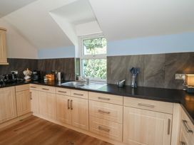 A kitchen with wooden cabinets and sink at 1 Bryn Beudy Stepaside