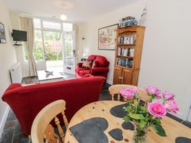 A living room with a red sofa and television at 3 Riverside Bungalows in Llanbedr