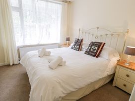 A bedroom with a large bed, bedside tables and lamps at 3 Riverside Bungalows in Llanbedr