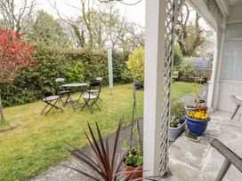 A garden with a table and chairs at 3 Riverside Bungalows in Llanbedr