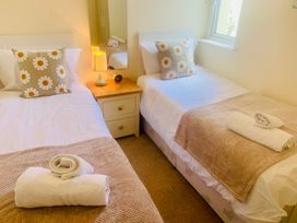 A bedroom with two beds and a lamp at 3 Riverside Bungalows Llanbedr