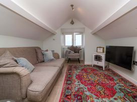 A living room with a sofa and television at Sea Sanctuary