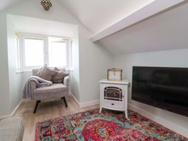 A snug with an armchair and television at Sea Sanctuary