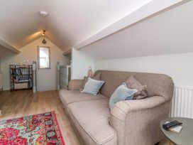 A snug area with a sofa and shelves at Sea Sanctuary