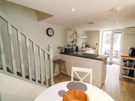 A kitchen with a clock and a dining area at Sea Sanctuary 