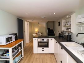 A kitchen with a microwave, cooker, and dining table at Sea Sanctuary