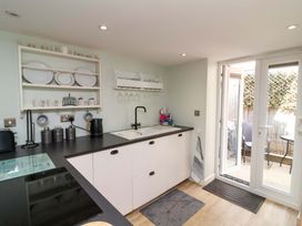 A kitchen with sink and shelves at Sea Sanctuary