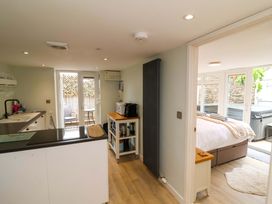 A kitchen with appliances and a doorway to a bedroom at Sea Sanctuary