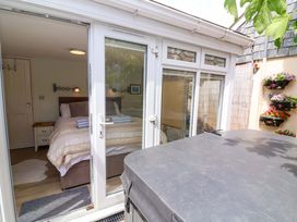 A bedroom with a bed and nightstand viewed from an outdoor area at Sea Sanctuary 