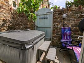 A hot tub and a chair in an outdoor space at Sea Sanctuary