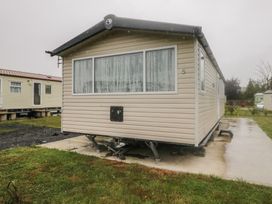 A caravan with large windows and a concrete base at Pinewood in Kidlington