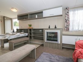 A living room with a dining area and an electric fireplace at Pinewood in Kidlington
