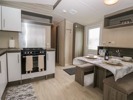 A kitchen with stove and dining set at Pinewood in Kidlington