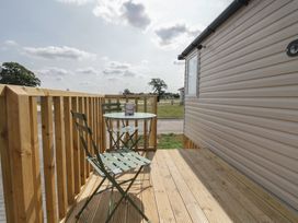 A deck with a table and chair at Pinewood in Kidlington
