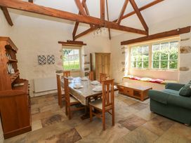 A dining room with a table and chairs and a sofa at Carreg Las Haverfordwest