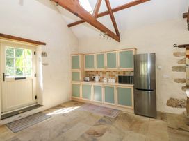 A kitchen with cabinets, a fridge, and a door at Carreg Las in Haverfordwest