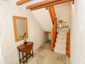 A hallway with a staircase and a mirror at Carreg Las in Haverfordwest