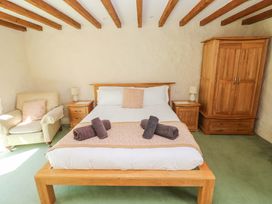 A bedroom with a bed and armchair at Carreg Las in Haverfordwest