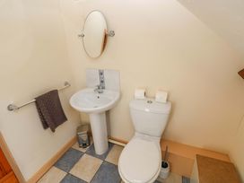 A bathroom with a sink and toilet with a mirror at Carreg Las Haverfordwest