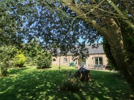 A stone house with furniture in a garden at Carreg Las in Haverfordwest