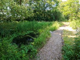 A garden path beside a pond at Carreg Las in Haverfordwest