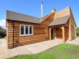 An exterior view of a house with a patio at Dingle in Cleobury Mortimer