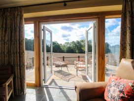 A living room with open double doors leading to a patio at Dingle in Cleobury Mortimer