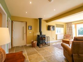A living room with a fireplace and television at Dingle in Cleobury Mortimer