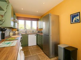 A kitchen with a refrigerator and dishwasher at Dingle in Cleobury Mortimer