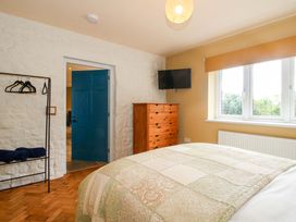 A bedroom with a bed and dresser at Dingle in Cleobury Mortimer