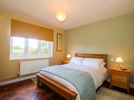 A bedroom with a bed and nightstands at Dingle in Cleobury Mortimer