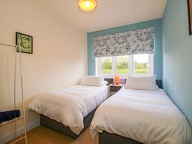 A bedroom with two beds and a window at Dingle in Cleobury Mortimer