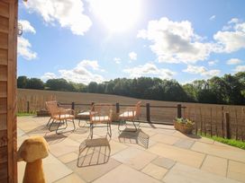 A garden patio with chairs and plants at Dingle Cleobury Mortimer