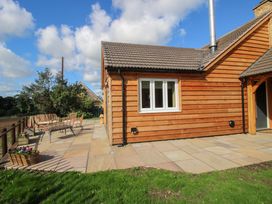 A house with a patio area and outdoor furniture at Dingle in Cleobury Mortimer