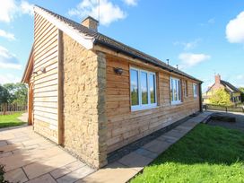 An exterior view of a wooden house with stone accents at Dingle, Cleobury Mortimer
