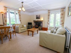 A living room with a sofa and dining table at Disgwylfa Sarn Mellteyrn